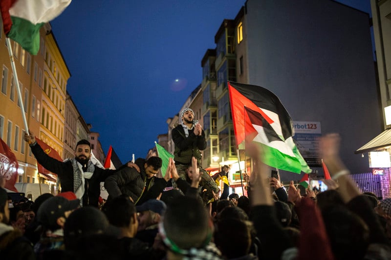 Evening protest where people wave Palestinian flags