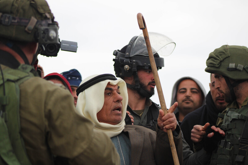 Man surrounded by soldiers gestures and speaks