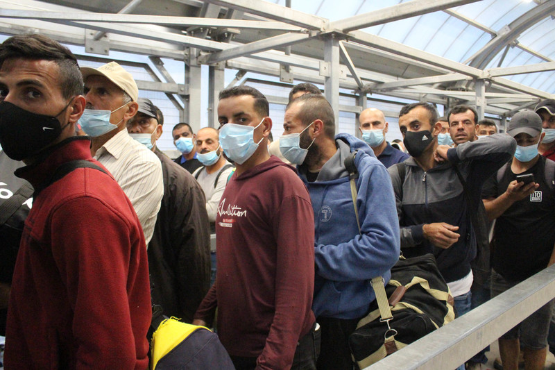 Men wearing surgical masks in queue 
