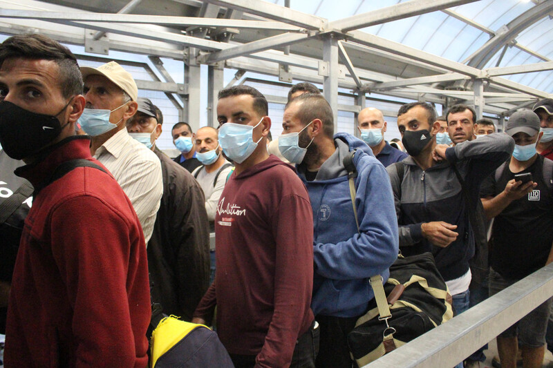 Men wearing surgical masks in queue