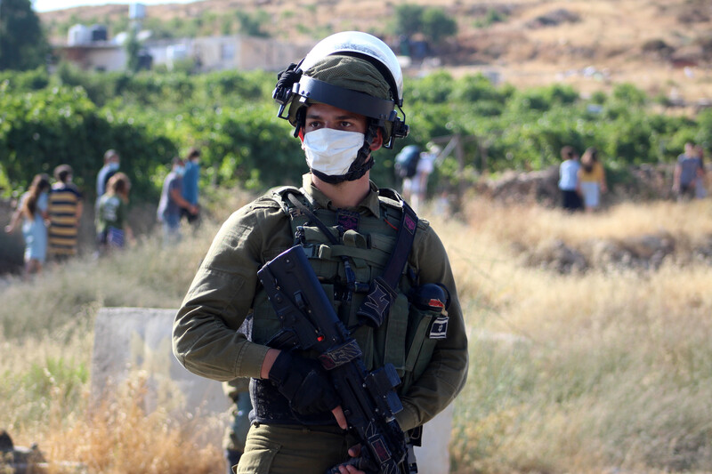 Heavily armed soldier wearing protective mask 