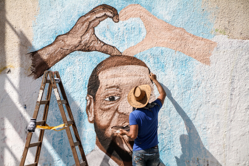 A man paints a mural on a wall in Gaza