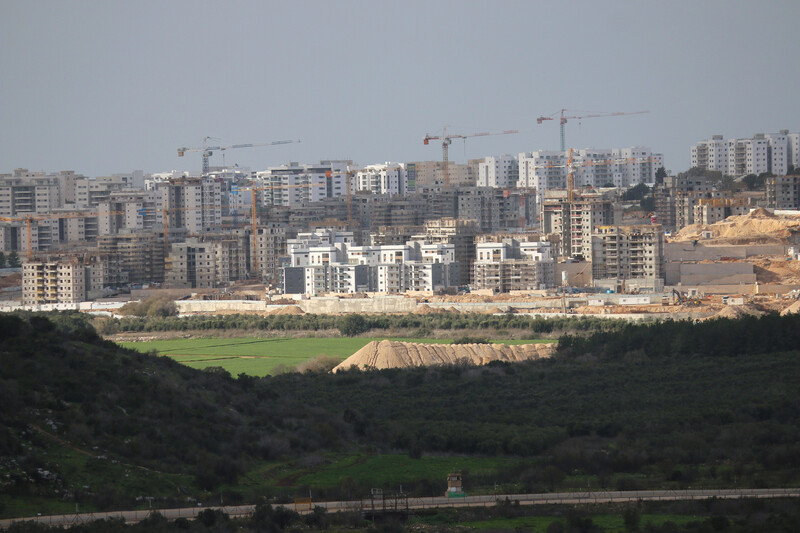 Construction cranes tower over apartment buildings