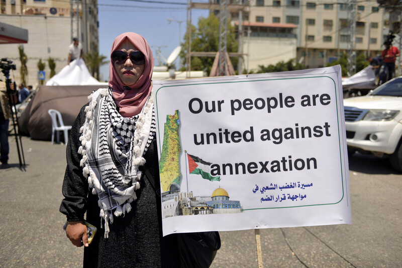 Woman in sunglasses holds sign