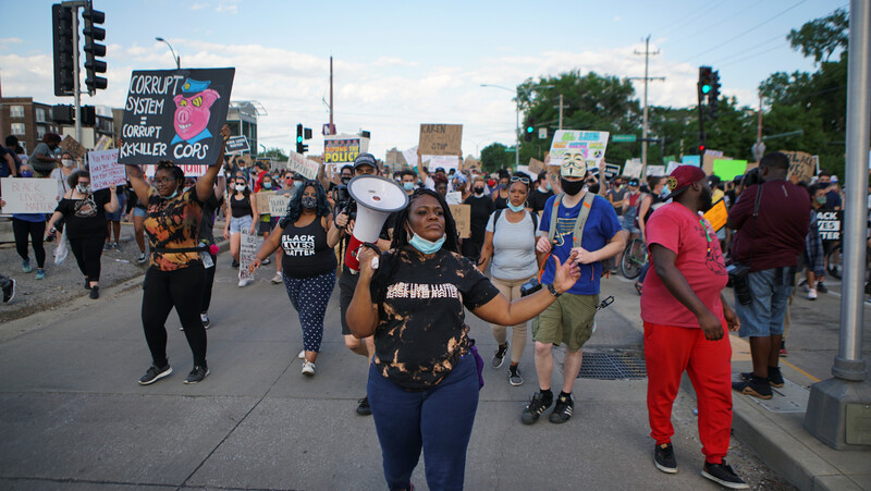 Woman with megaphone leads marching protesters