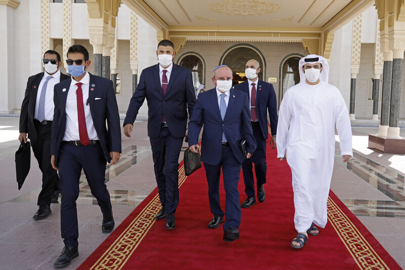 Men in protective masks walk out of building