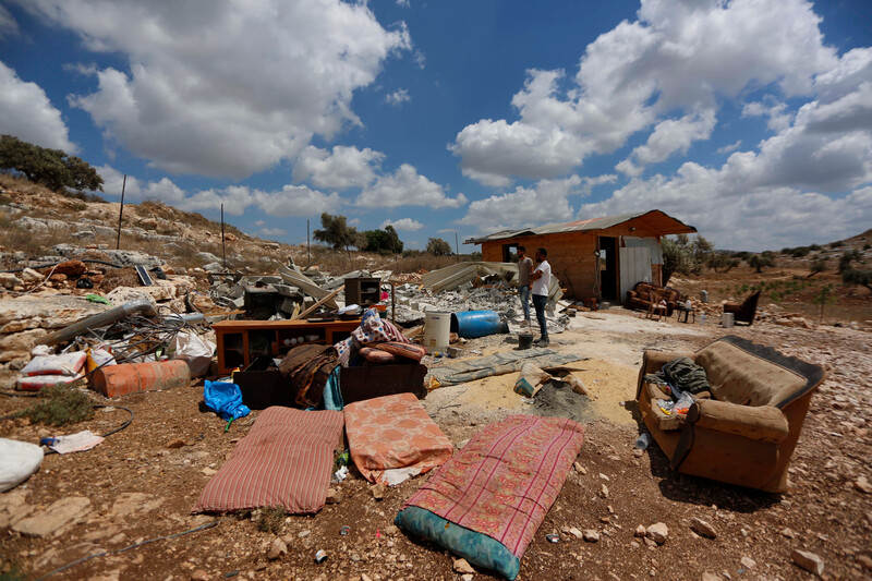 Damaged furniture and rubble on open land 