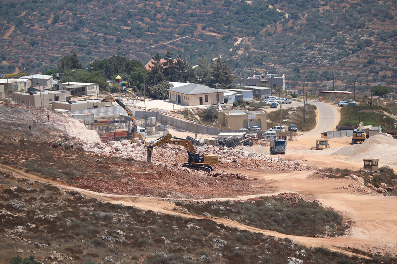 Bulldozer builds structure on open land 