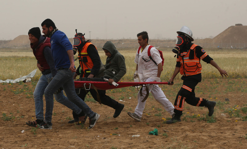 Medics rush an injured demonstrator to safety.
