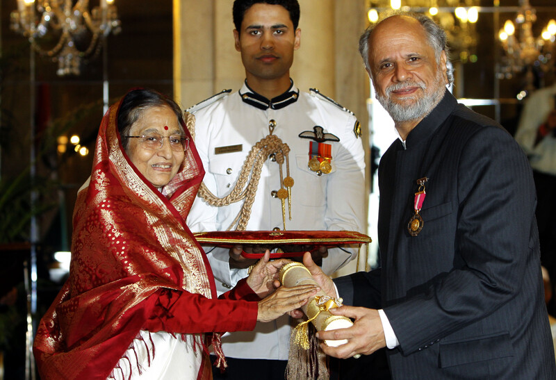  Man receives object from woman as ceremonial guard looks on