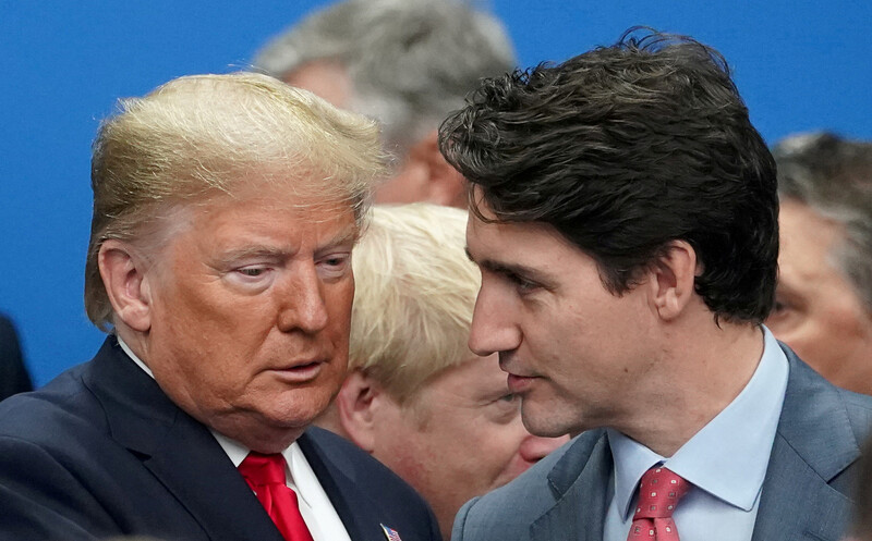 Two men in suits talk to each other.