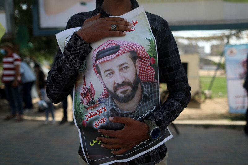 A man embraces a poster of a man 