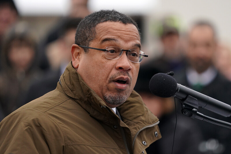 Man in winter coat speaks at microphone