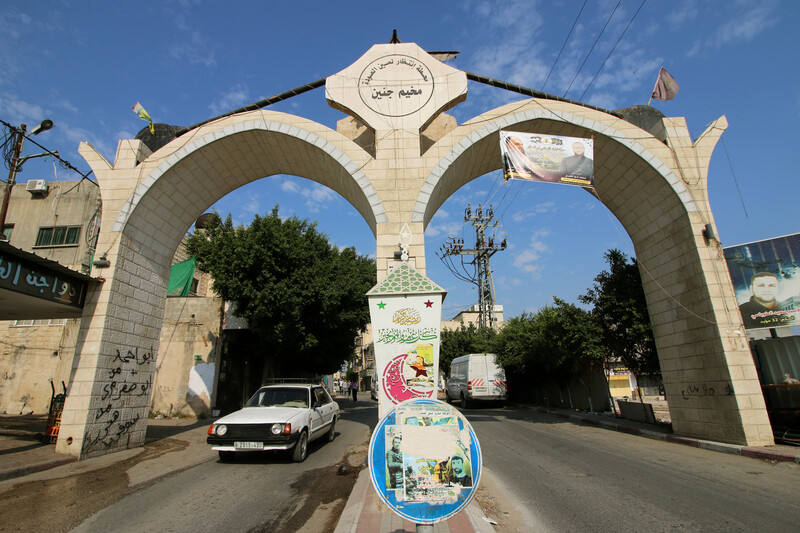 Two connected stone arches loom over a road