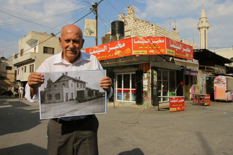 A man holds up a black and white photo