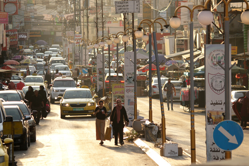 Cars and pedestrians hustle for space on a busy street