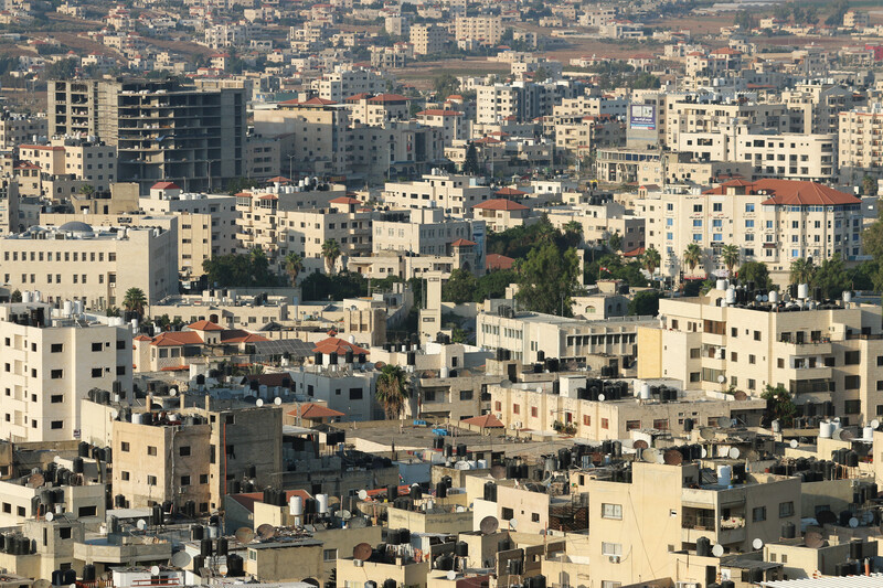 A city sprawls, seen from above