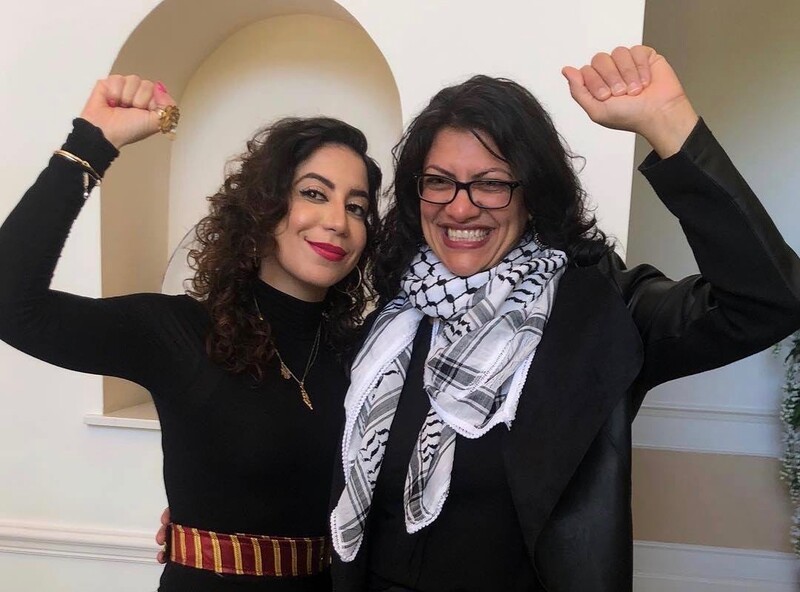 Two women embrace and raise fists