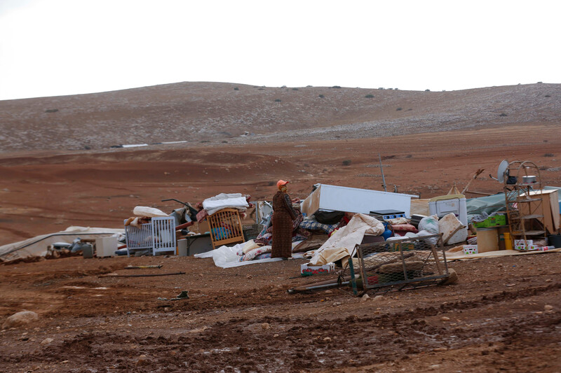 Woman inspects destroyed structures