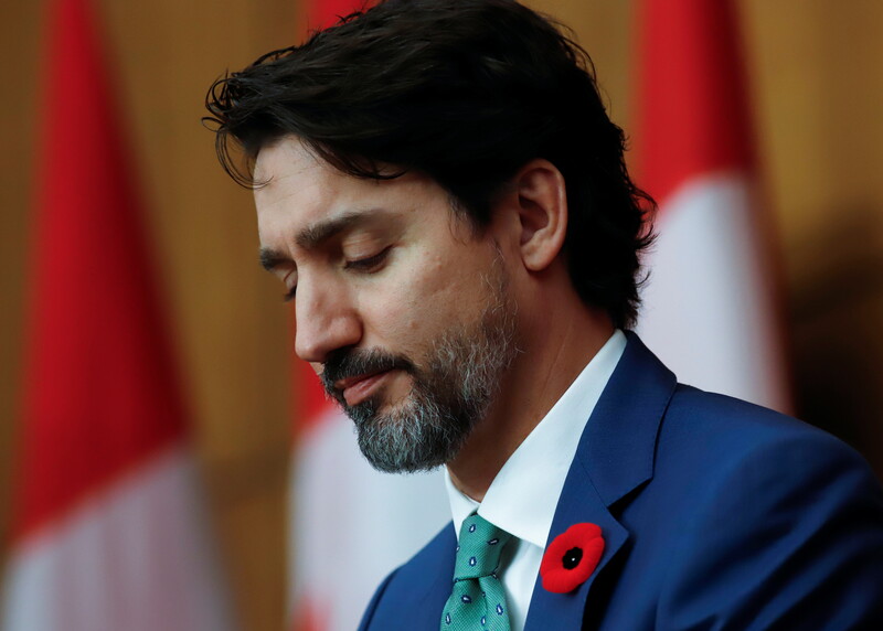 A man in a suit looks downward