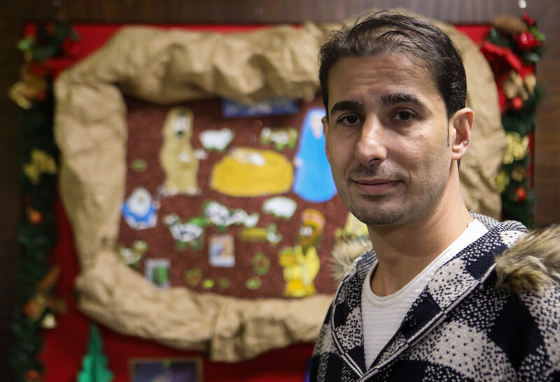 A man stands in front of Christmas decorations