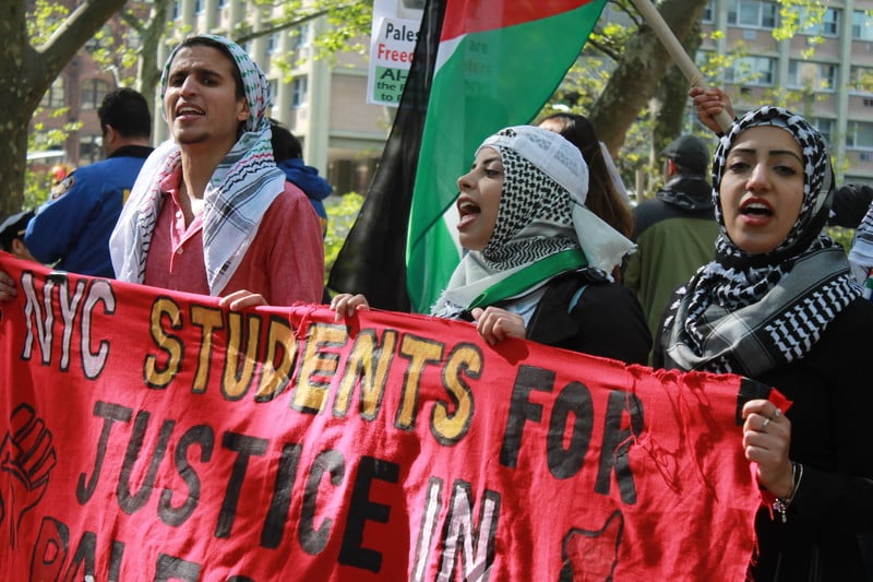 Demonstrators hold a banner that says Students for Justice in Palestine