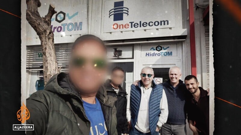 A group of men pose for a picture. Two faces are blurred 