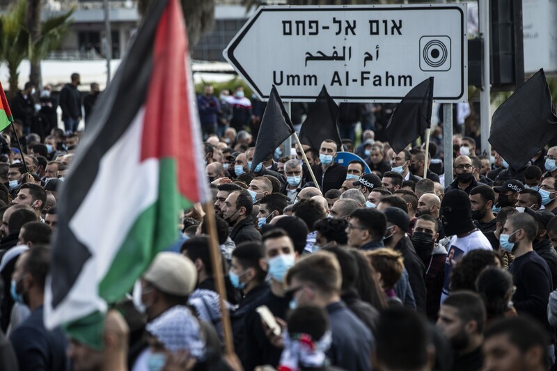 People demonstrate in large numbers, holding flags