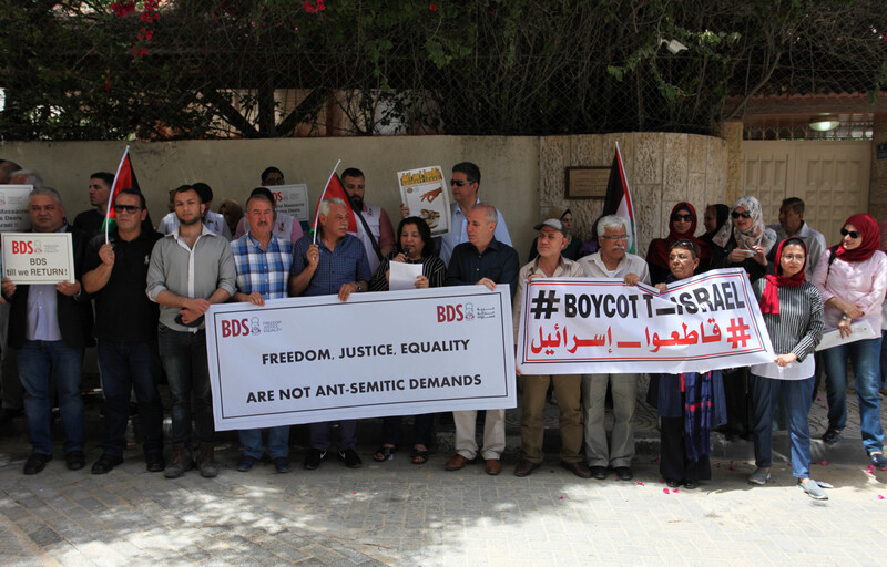 People stand holding banners