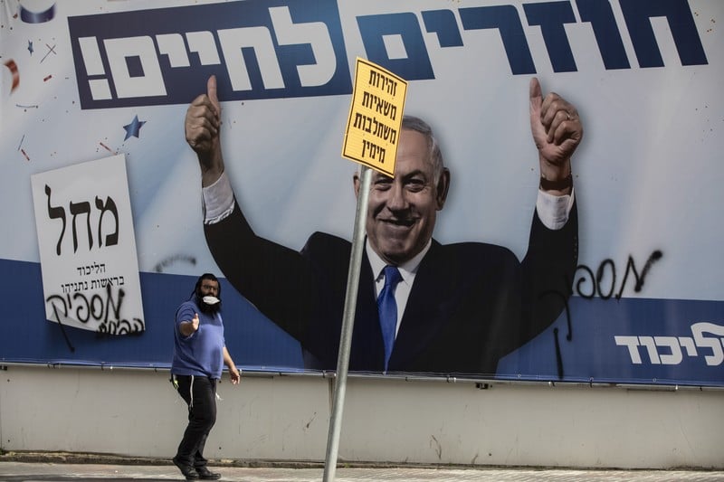 An election poster covered with graffiti carries Benjamin Netanyahu's triumphant image