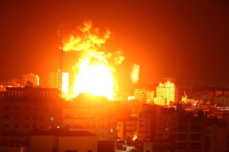 Landscape view of a massive fireball over a city skyline at night