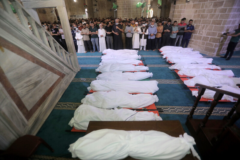 People pray at the mosque over 17 bodies wrapped in white cloth