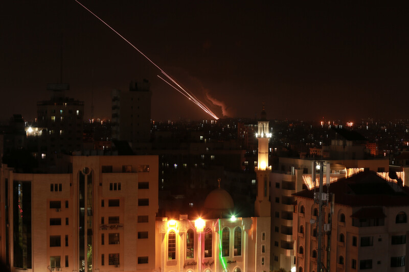 A streak of light from a rocket blazes through a dark sky