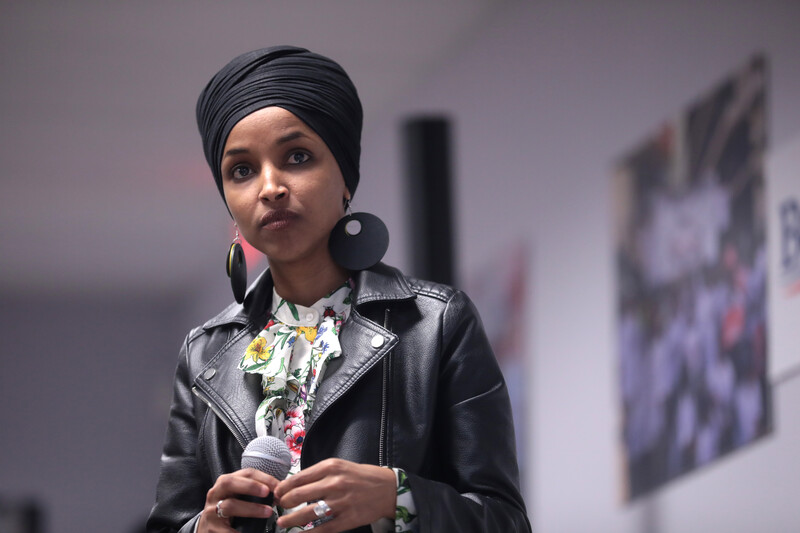 Woman leather jacket stands holding microphone