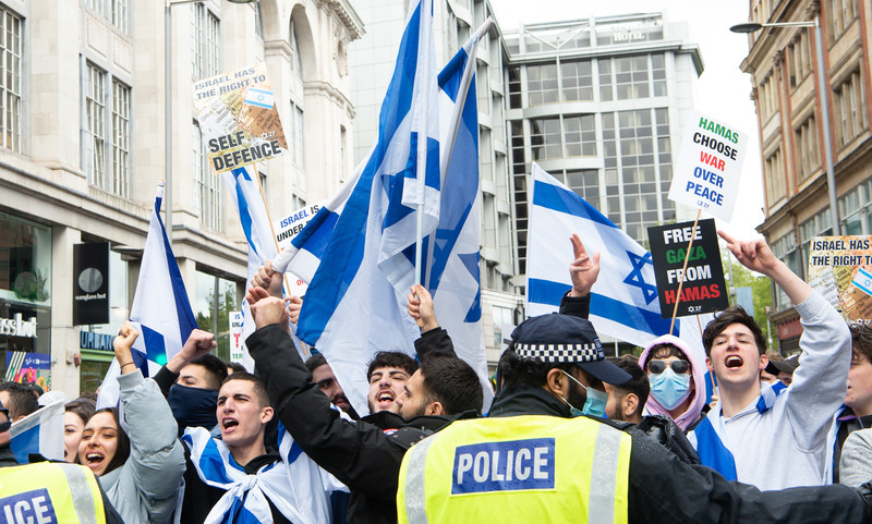 Young people waving Israeli flags and chanting