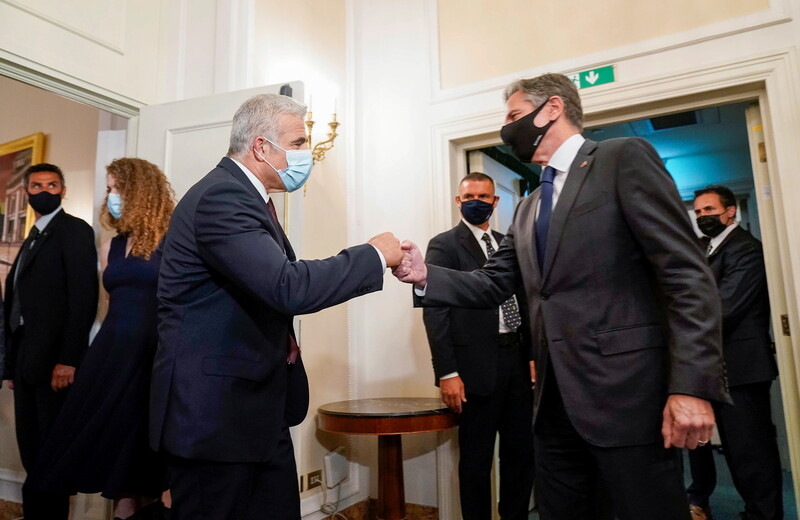 Two men bump fists while others look on