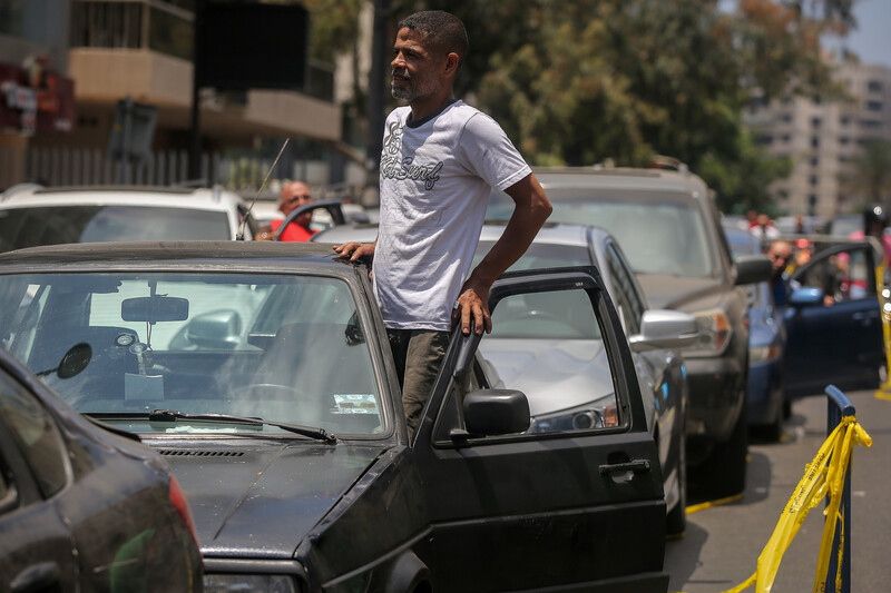 Man steps out the door of his car amid queue 