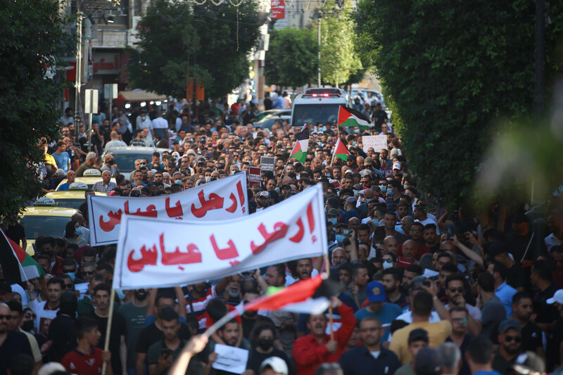 Large crowd of demonstrators holding two large banners, flags 