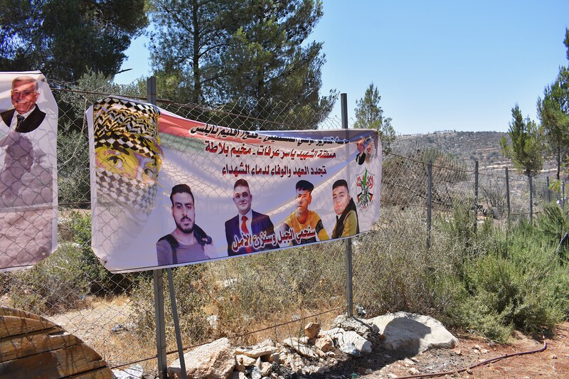 A banner depicting four young men hangs on a fence