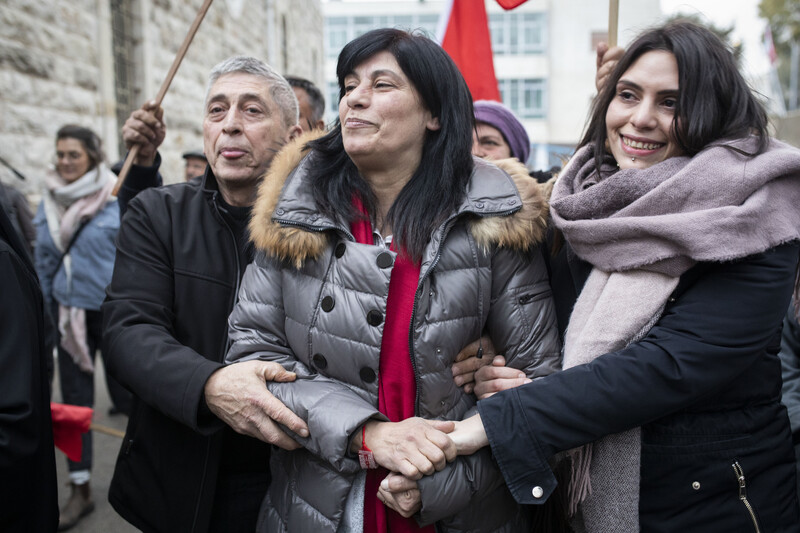 A woman is flanked by a man and a woman