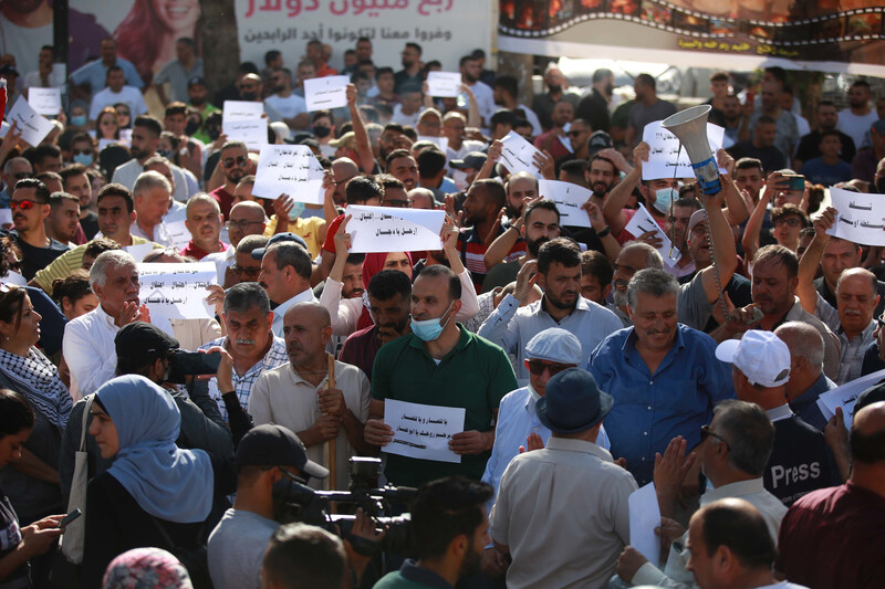 Demonstrators hold up signs in Arabic