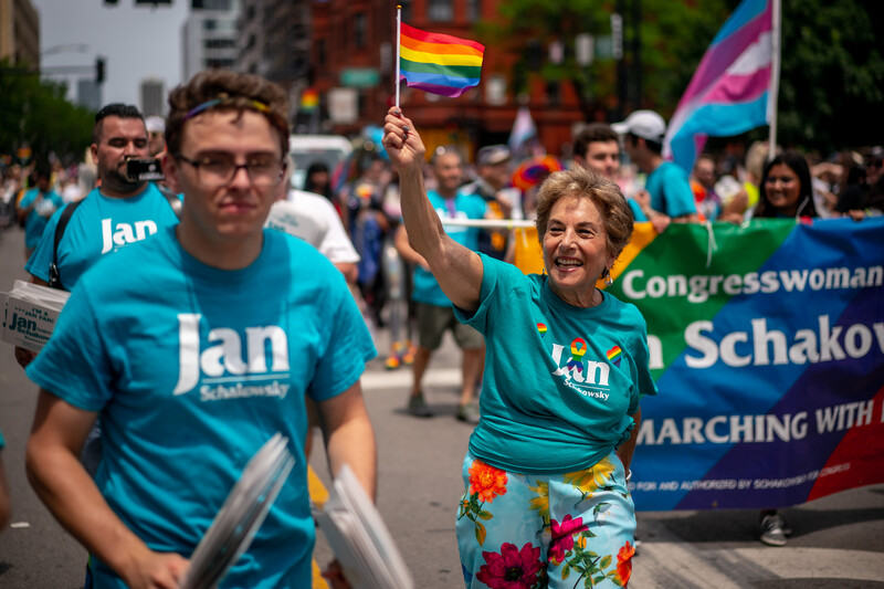 Woman waves rainbow flag as people march