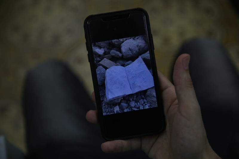A picture of a picture on a mobile phone of tattered piece of paper