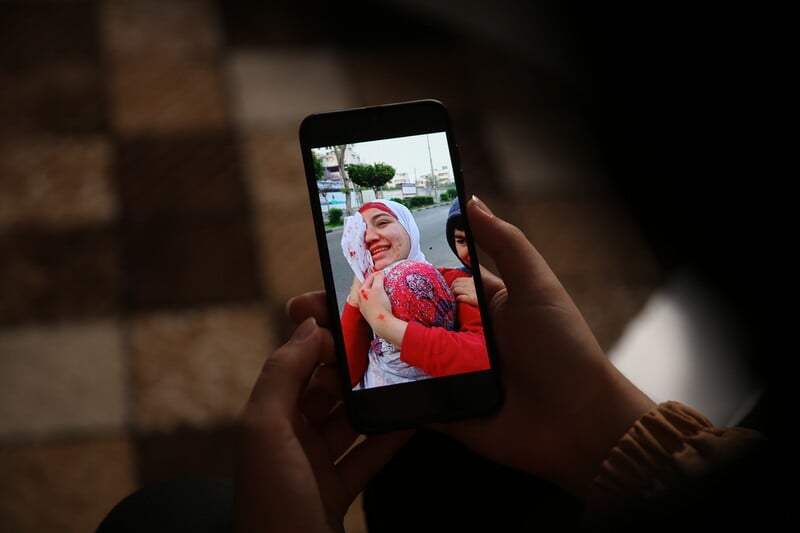 A picture of a picture on a mobile phone of a woman with blood on her face