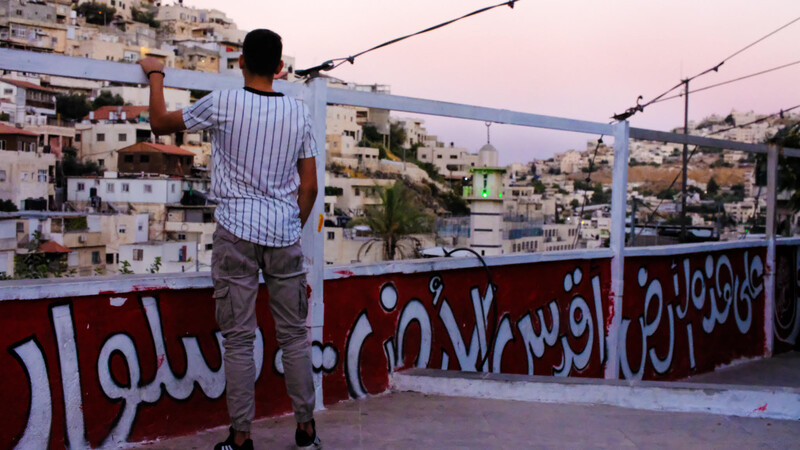 A man looks over a rooftop painted with a mural 