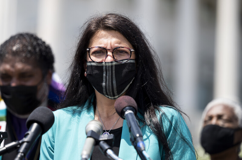 Woman at microphones with two people behind her