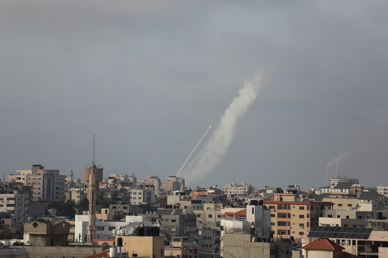 Landscape view of rocket fired into air with smoke streaking behind it