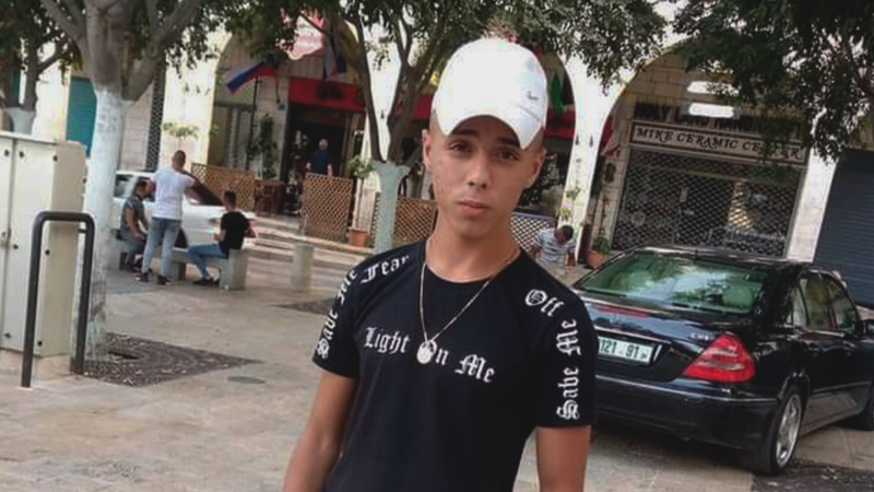 Boy stands in the street wearing cap 