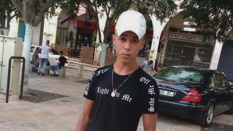 Boy stands in the street wearing cap