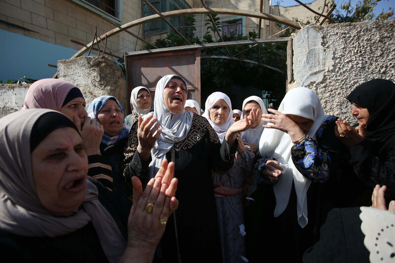 Women weeping and crying at the entrance to a house